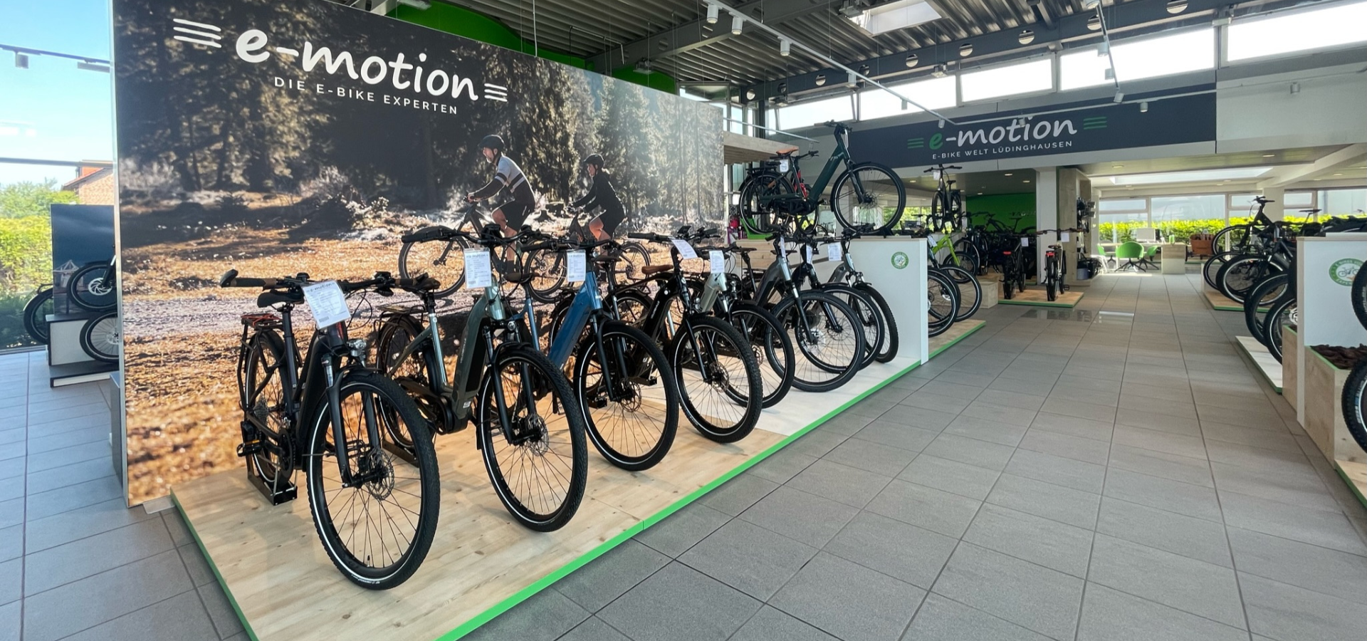 Großformatige Wandbilder und bodentiefe Podeste verleihen der Verkaufsfläche der e-motion E-Bike Welt in Lüdinghausen eine klare Struktur. Der Store wurde von Schemberg Ladenbau geplant und umgesetzt.